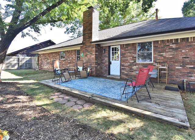 back of property featuring a lawn and a deck