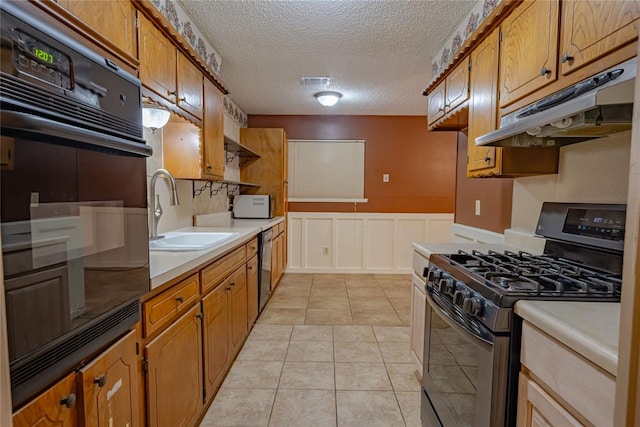 kitchen featuring black appliances, light tile patterned floors, sink, and a textured ceiling