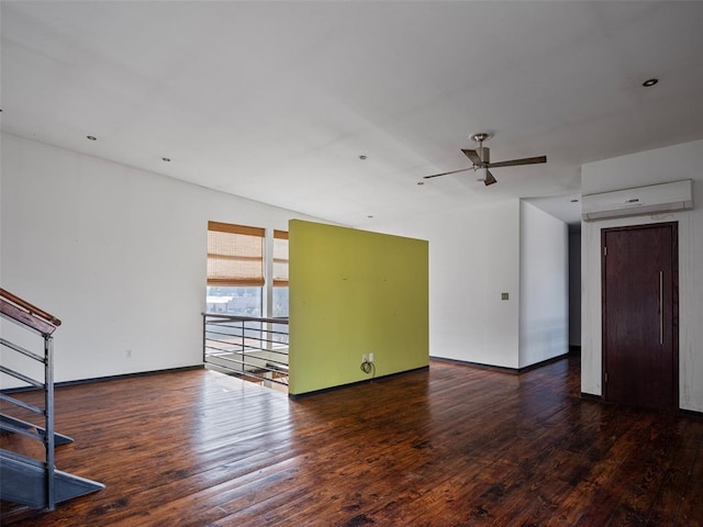 unfurnished living room with ceiling fan, dark wood-type flooring, and a wall mounted AC