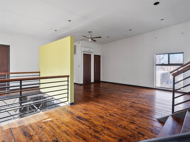 unfurnished living room with dark wood-type flooring and an AC wall unit