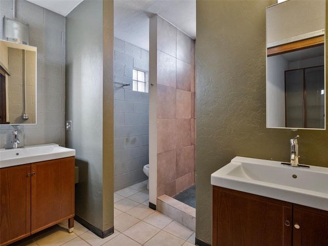 bathroom with tiled shower, tile walls, vanity, tile patterned flooring, and backsplash