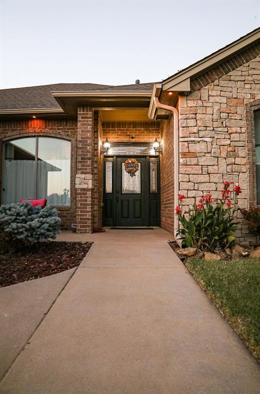 property entrance with stone siding and brick siding