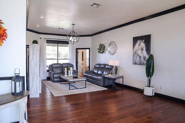 living room with crown molding, hardwood / wood-style floors, baseboards, a textured ceiling, and visible vents