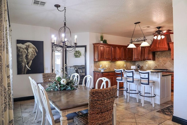 dining room with baseboards, a textured ceiling, visible vents, and ceiling fan with notable chandelier