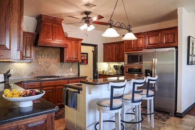 kitchen featuring tasteful backsplash, stainless steel appliances, dark countertops, visible vents, and a ceiling fan