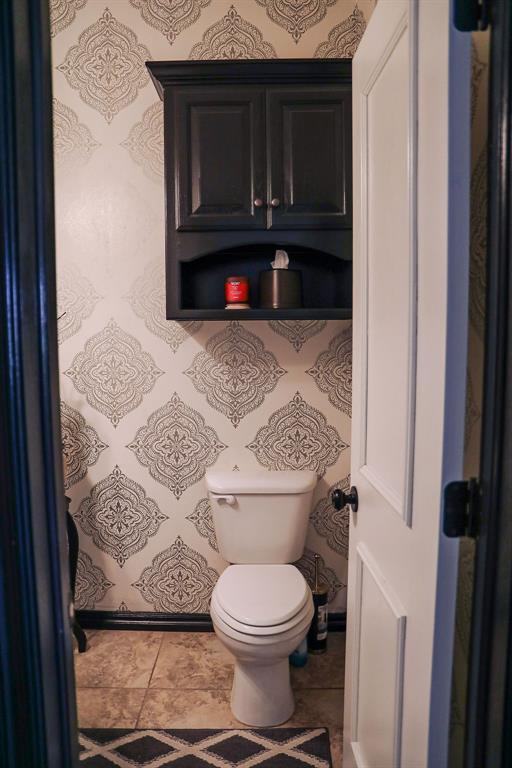 bathroom with toilet and tile patterned floors
