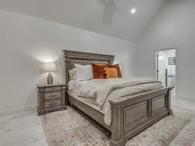 bedroom featuring high vaulted ceiling and ensuite bath