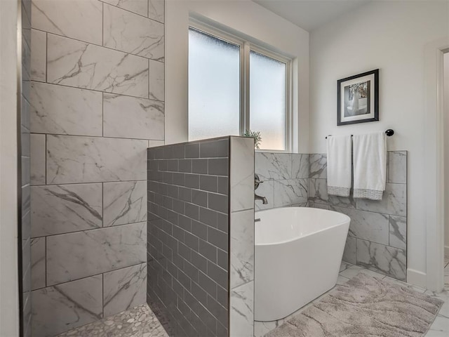 bathroom with a bath and tile walls