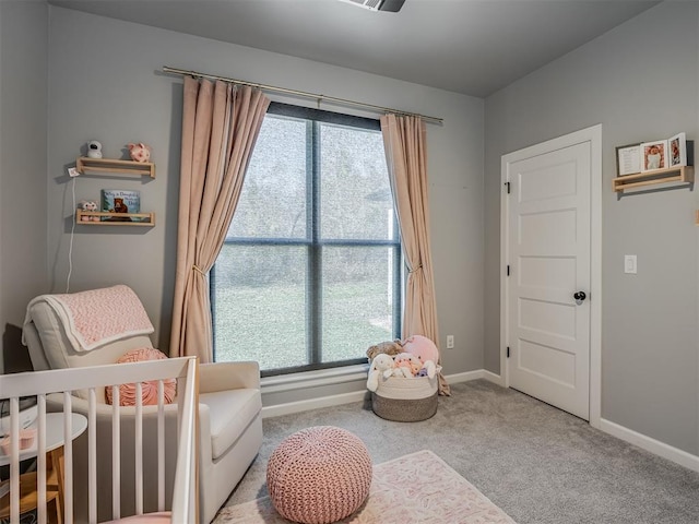 bedroom with light colored carpet, multiple windows, and a nursery area