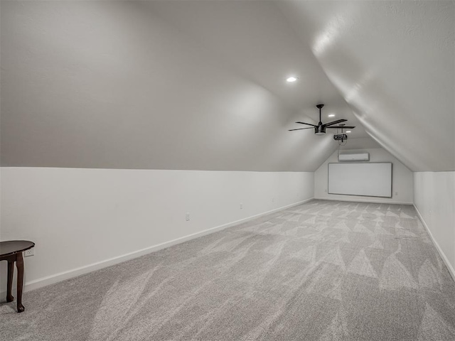 additional living space featuring light carpet, vaulted ceiling, ceiling fan, and an AC wall unit