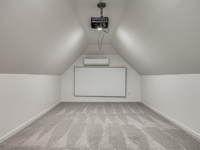 bonus room featuring a wall mounted air conditioner, light colored carpet, and vaulted ceiling