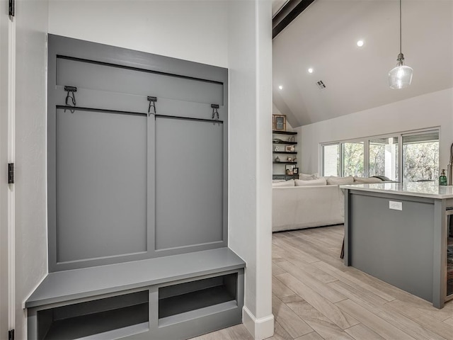 mudroom with high vaulted ceiling and light wood-type flooring