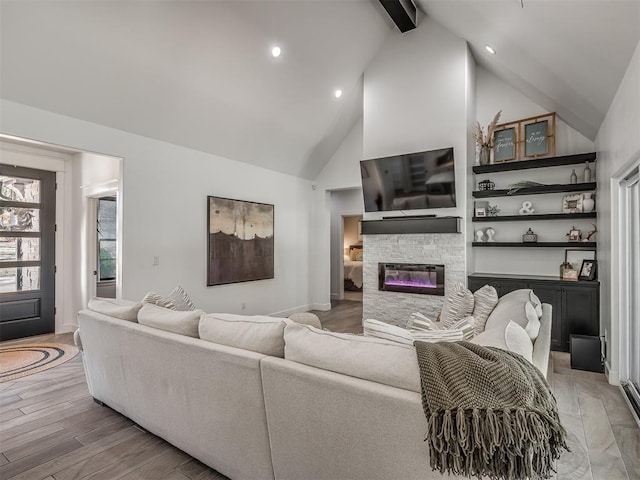 living room featuring hardwood / wood-style flooring, beam ceiling, a fireplace, and high vaulted ceiling