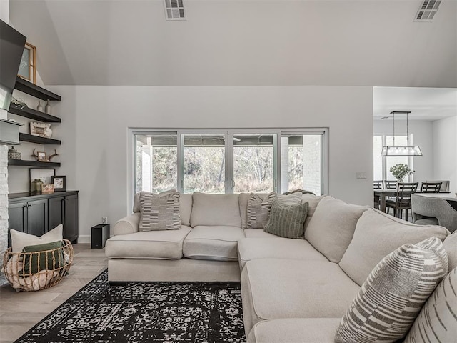 living room featuring light wood-type flooring and vaulted ceiling