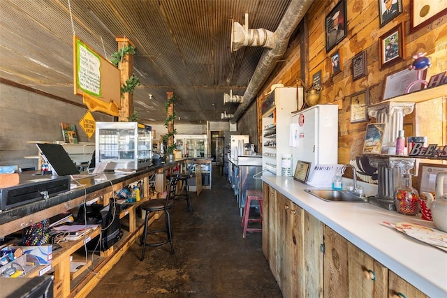 kitchen featuring wood walls and sink