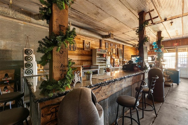 kitchen featuring concrete flooring and wooden walls