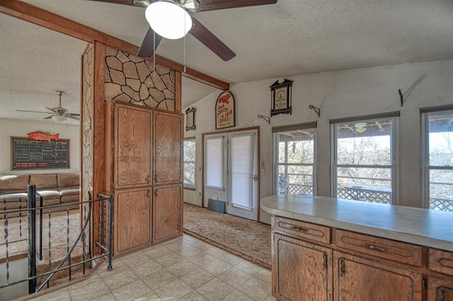 kitchen with vaulted ceiling with beams and a textured ceiling