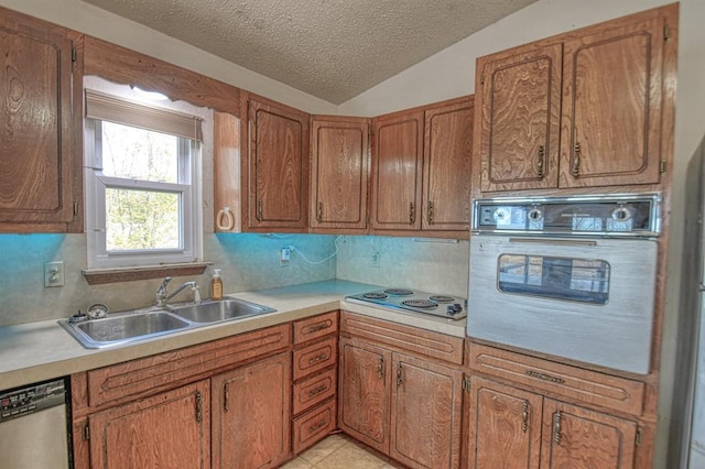 kitchen with lofted ceiling, oven, sink, stainless steel dishwasher, and a textured ceiling