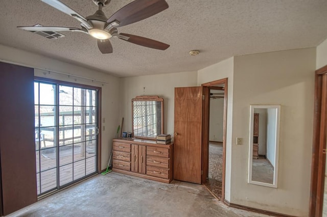 21351 E Tenth St, Hinton, OK 73047 - unfurnished bedroom with access to exterior, a textured ceiling, unfinished concrete floors, and a ceiling fan