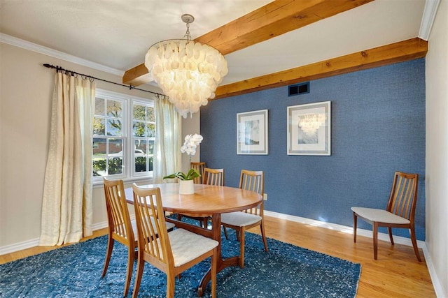 dining area featuring hardwood / wood-style floors, ornamental molding, a notable chandelier, and beam ceiling