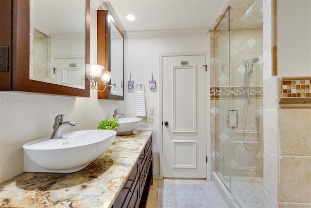 bathroom with tile patterned flooring, vanity, a shower with door, and ornamental molding