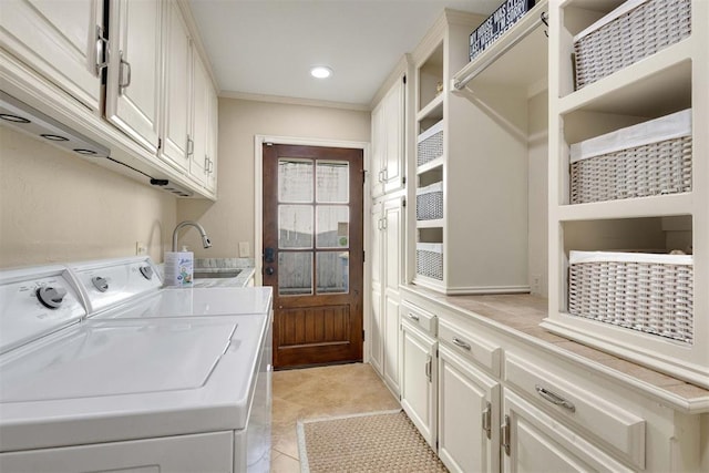 laundry room with washer and dryer, cabinets, light tile patterned floors, and sink