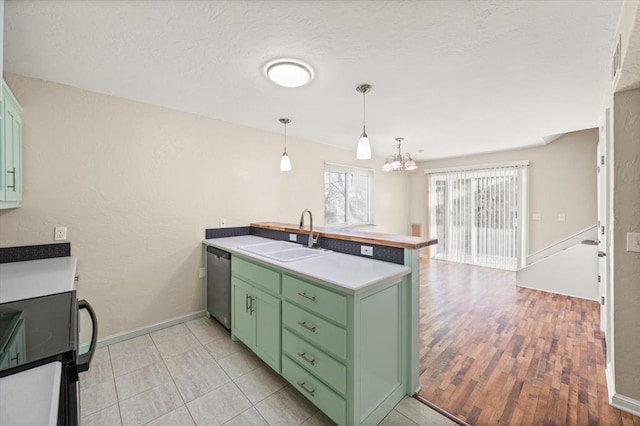 kitchen with dishwasher, an inviting chandelier, sink, green cabinetry, and light wood-type flooring