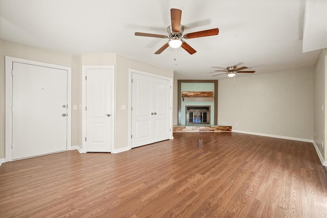 unfurnished living room with ceiling fan and wood-type flooring