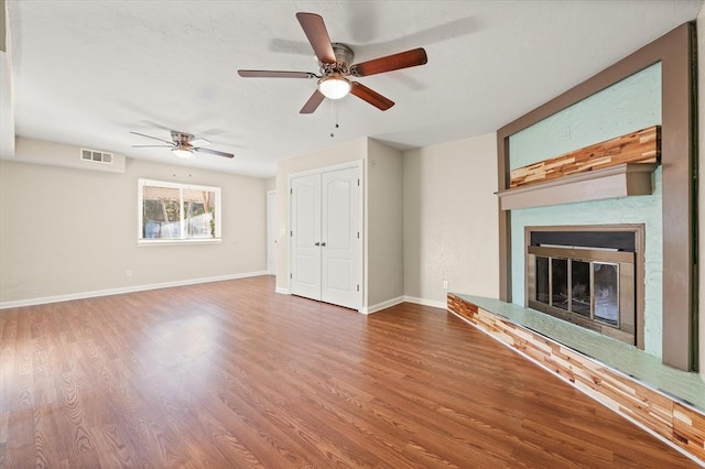 unfurnished living room with ceiling fan and hardwood / wood-style floors