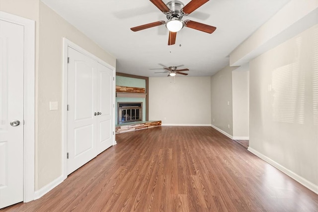 unfurnished living room with ceiling fan and wood-type flooring