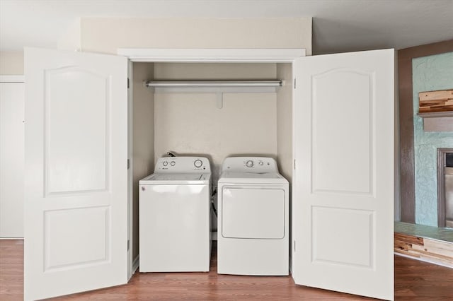 washroom with independent washer and dryer and hardwood / wood-style flooring