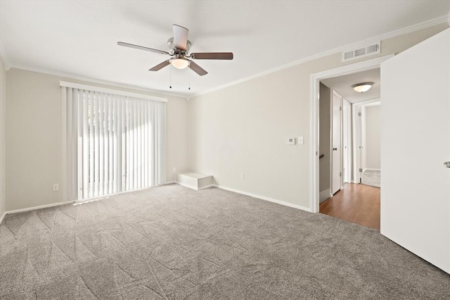 carpeted spare room with ceiling fan and ornamental molding