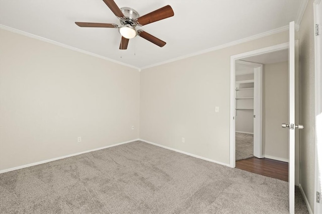 carpeted spare room with ceiling fan and ornamental molding