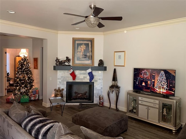 living room featuring a fireplace, dark hardwood / wood-style floors, ceiling fan, and crown molding