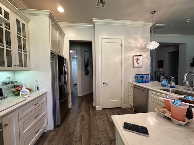 kitchen featuring appliances with stainless steel finishes, dark hardwood / wood-style flooring, crown molding, sink, and decorative light fixtures