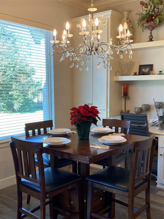 dining room with crown molding, dark hardwood / wood-style flooring, and a notable chandelier