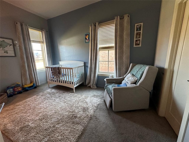 carpeted bedroom featuring a crib