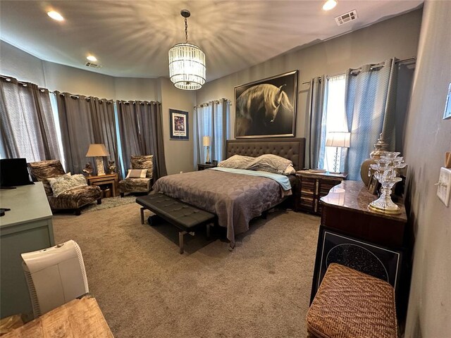 carpeted bedroom featuring an inviting chandelier