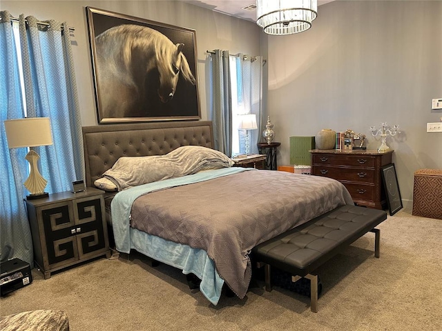 carpeted bedroom featuring a notable chandelier