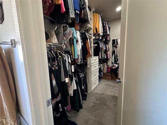 walk in closet featuring light colored carpet