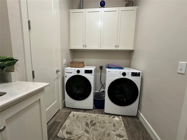 laundry room with cabinets, dark wood-type flooring, and washing machine and clothes dryer