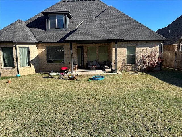 back of house with a patio area and a lawn