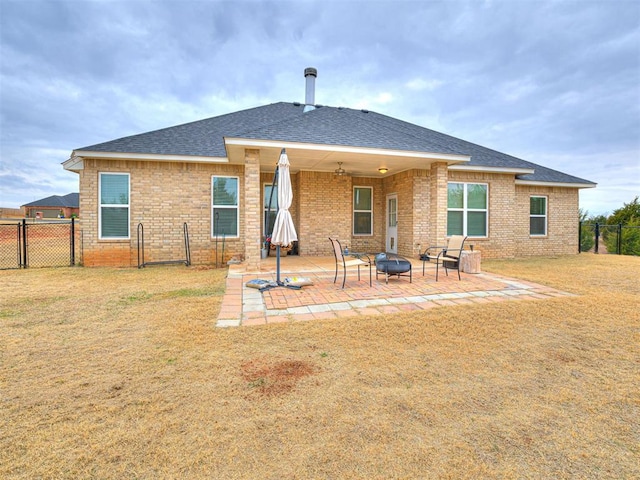 rear view of house featuring a yard, a patio, and a fire pit