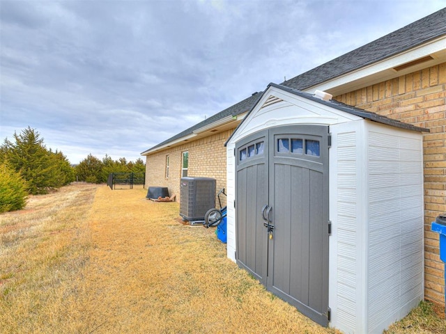 view of outbuilding featuring cooling unit and a lawn