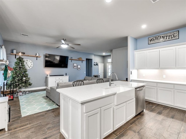 kitchen with white cabinets, ceiling fan, a kitchen island with sink, sink, and dishwasher