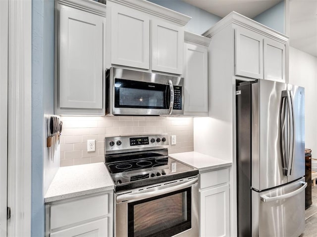 kitchen featuring decorative backsplash, white cabinetry, and stainless steel appliances