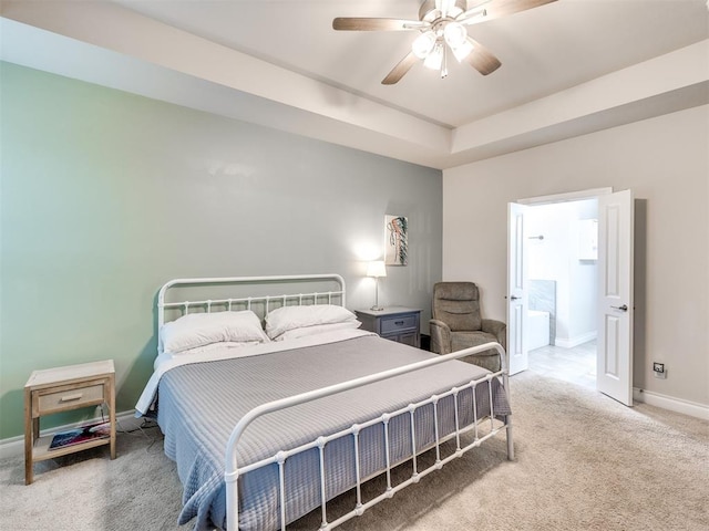 carpeted bedroom featuring ceiling fan and a raised ceiling