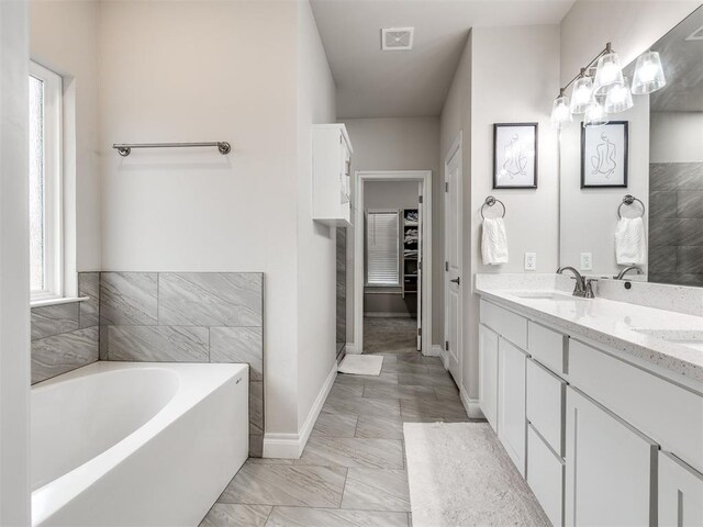 bathroom with a bathing tub and vanity