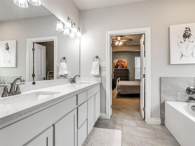 bathroom featuring ceiling fan, vanity, and a washtub