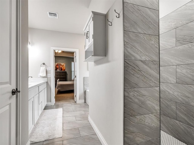 bathroom featuring vanity and tiled shower